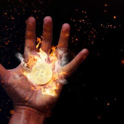 Human,Hand,With,A,Burning,Bitcoin.